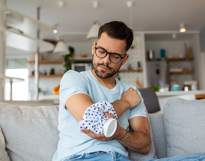 Person applying ice pack to elbow