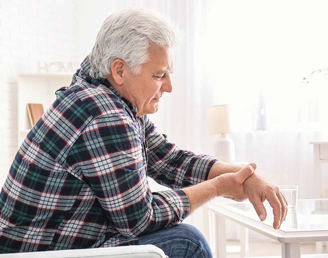 Older adult holding wrist in discomfort